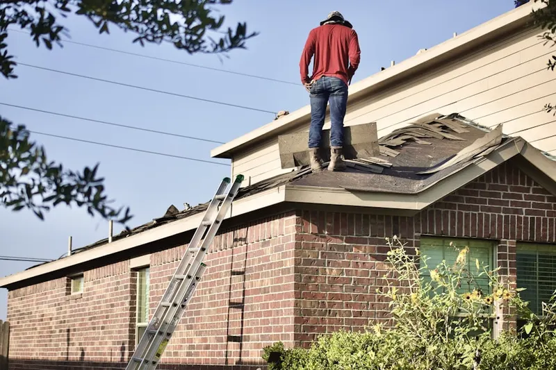 Professional roofer working on a residential roof in Kings Point Condominiums